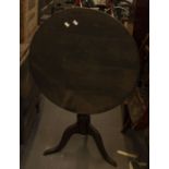 An ebonised georgian tripod tilt-top table, circular top with metal bracket on cabriole legs 68cm