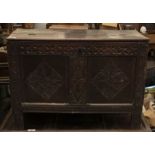 An 18th century and later oak coffer, later hinged top, carved double panel front on carved stile