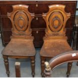 A pair of 19th Century mahogany hall chairs carved back with solid wood seat on front turned legs