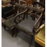 A 19th century armchair with carved single splat and scrolling arms on fluted sabre legs together