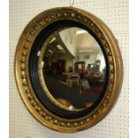 A Regency giltwood wall mirror, the circular frame with ball decoration, ebonized slip and convex