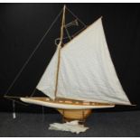 A large mid 20th century single masted pond yacht, kit built, with rigged linen sails. 124cm bow