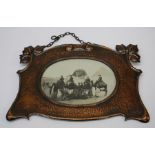 An early 20th century Arts and Crafts spot hammered copper photograph frame with scroll and leaf