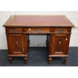 An Edwardian oak twin pedestal writing desk, the rectangular top over three frieze drawers and a