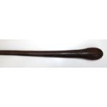 A wooden club with incise carved head and shaft, 89cm