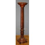 A mahogany torchere, the circular top over a twist column and circular base, H125cm