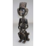 An Ashanti hardwood maternity figure seated and holding a child. H56cm