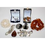 An amber necklace of irregular graduated beads, three pairs of amber earrings and a sterling
