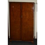 An early 20th century figural mahogany wardrobe enclosed by a pair of full length panel doors,