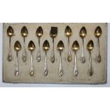 A continental silver and silver gilt set of 12 glace spoon , the terminals decorated with flowers,