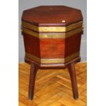 A George III mahogany and brass bound octagonal wine cooler the rising top over a fitted interior,