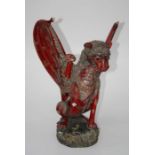 An early 20th century Indonesian polychrome painted carved wood figure of a winged mythical beast,
