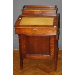 An Edwardian oak Davenport desk, the twin well fitted stationary compartment over tooled scriber