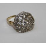 A diamond cluster ring of flower head form, having rub over set brilliant cut of approx. 0.2ct to