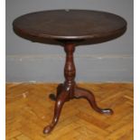 A late George III walnut tripod table, the circular snaptop carved on a birdcage and baluster