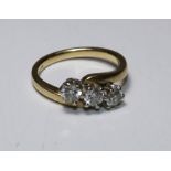 An 18ct three stone diamond ring, claw set three brilliant cut diamonds, total diamond weight