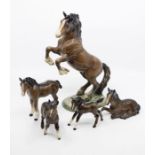A rearing Beswick horse, together with four foals including a shire foal and shetland foal