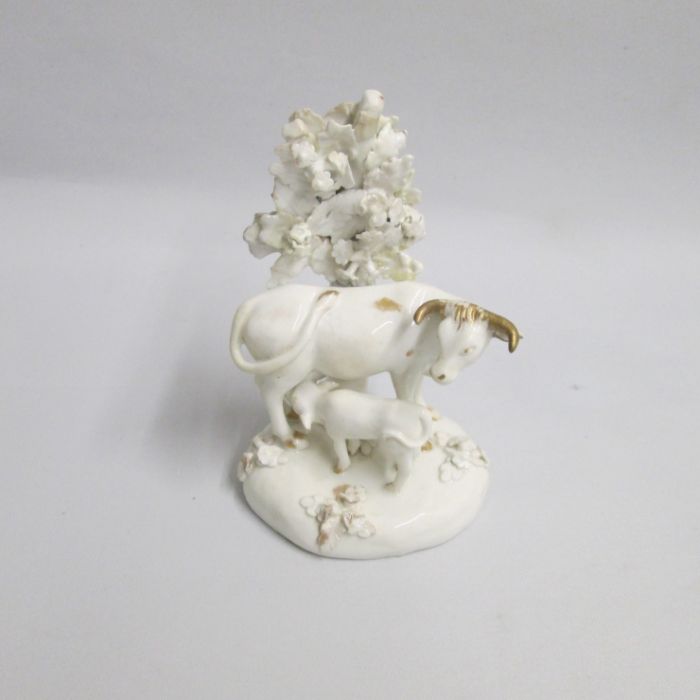A Derby White and Gilt cow and suckling calf standing before bocage Circa: 1800 Size: 15cm high