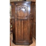A 1930's oak hallrobe with linen fold carved panelled sides, internal shelf and vanity mirror and