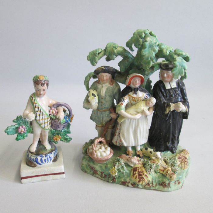 A Staffordshire Tithe Pig Group along with a small Staffordshire Cherub holding a basket of flowers,