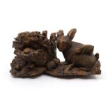 A charming early to mid 20th Century Black Forest style carving of a rabbit and kits in foliage,