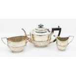A George V three-piece silver tea set, comprising teapot, milk and sugar, gadrooned bodies, ebonised