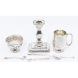 A collection of hallmarked silver including a christening mug, a weighted candlestick, a sugar