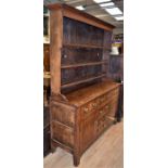 A George III kitchen dresser in oak, with three shelves, plate rack, three top drawers, above, three