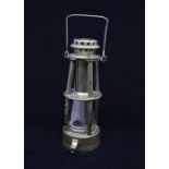 A late 19th Century miners safety lamp by Davis of Derby pierced canopy above two tiers, on four