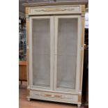 An early 20th Century French armoire / bookcase, painted grey with gilt detail, single base