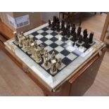 A decorative onyx chess board of large scale with accompanying resin chess pieces