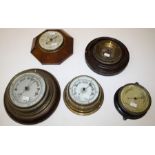 Five various aneroid barometers in oak carved walnut and metal cases. Largest 27cm diameter,