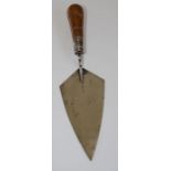 A silver bladed trowel with turned wooden handle, the blade inscribed ' Jacobo M Higginson arinigavo
