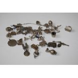 A silver charm bracelet and in excess of two dozen silver articulated and other charms