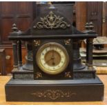 Slate mantel clock. Cast panels to front. Brass finials. Single train movement. 4.5 two piece