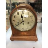 A dome shaped mahogany Edwardian mantle clock, eight day, with chime, Arabic numerals, batwing inlay
