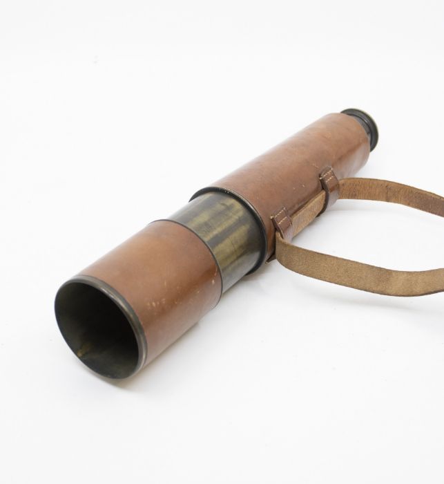 An early 20th Century brass telescope in a leather case with carry strap