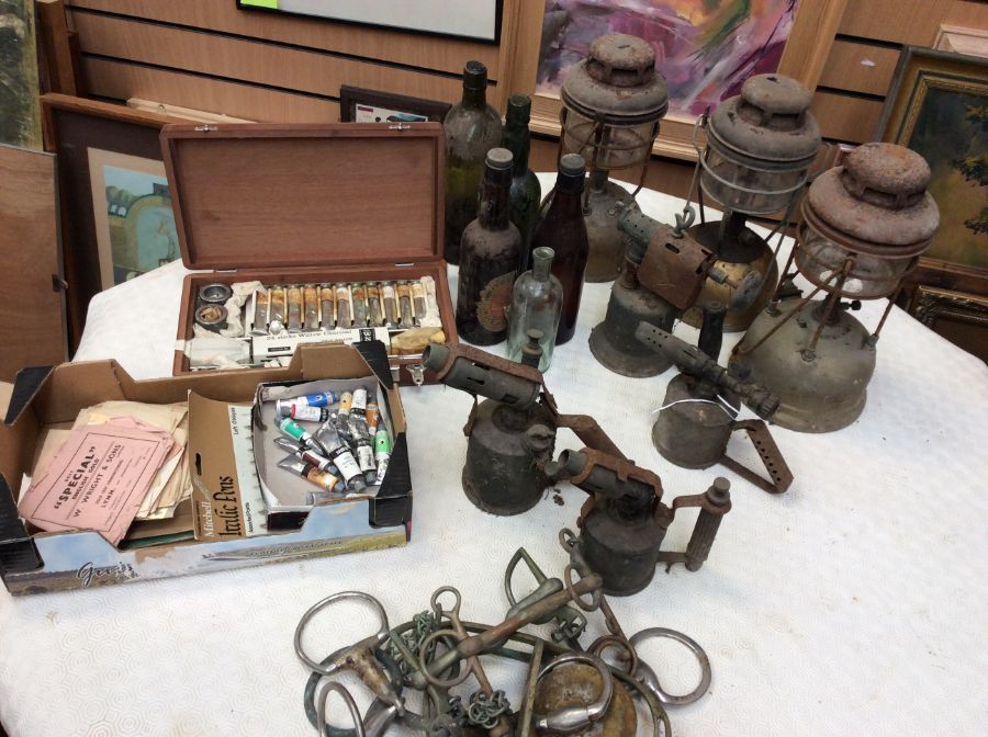 A collection of vintage Tilley lamps, blow lamps, vintage bottles and oil painting box with oil