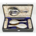 A George V matched six piece silver mounted dressing table set in fitted case, engraved with