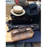 Black metal deed chest along with leather doctors bag boater hat and sausage dog draft stopper