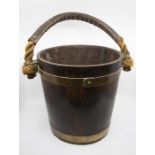 An early 20th Century wood and brass water/peat bucket with rope handle, label inside the rim