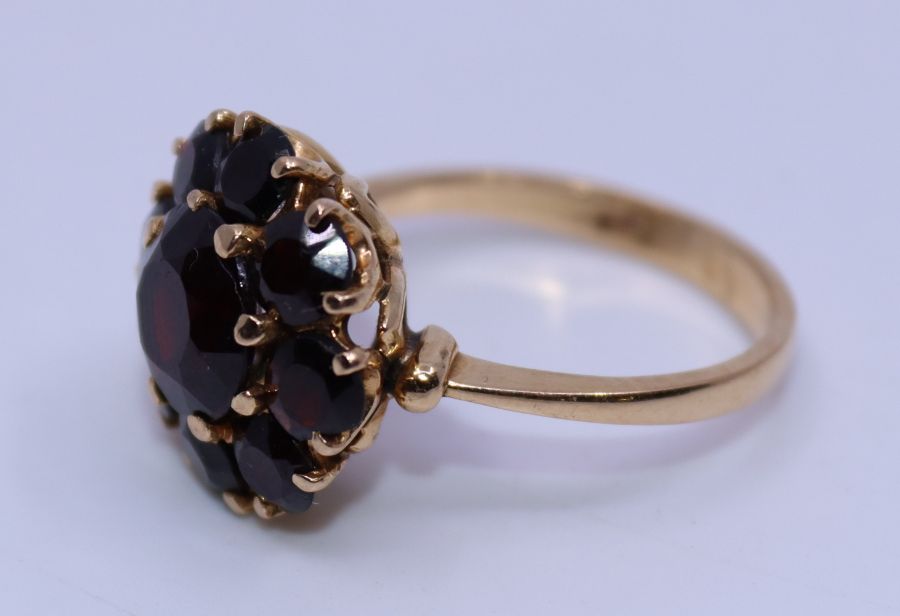 A precious yellow metal and garnet dress ring, the domed head claw set central round cut garnet - Image 2 of 2