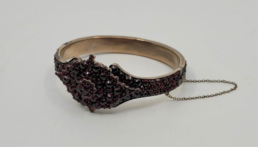 A silver-gilt and garnet hinged bracelet, pave set numerous rose cut garnets, gross weight 30.5g.