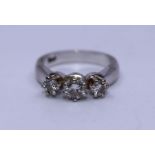 An 18ct. white gold three stone diamond ring, claw set three graduated round brilliant cut