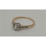 A precious yellow metal and diamond ring, set central round brilliant cut diamond with graduated