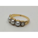 A Victorian precious yellow metal and natural pearl ring, having row of five graduated natural