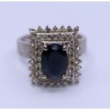 A Hoiman 18ct. white gold, sapphire and diamond dress ring, four claw set oval mixed cut sapphire to