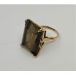 A 9ct. gold and topaz cocktail ring, four claw set large smokey mixed rectangular cut topaz,