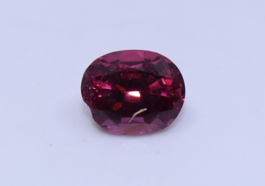 An oval mixed cut spinel, (7.5mm x 6mm x 4.5mm, approx. weight 1.0 carats +)