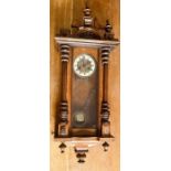 An early 20th century walnut Vienna wall clock, in a Gustav Becker style, turned finials on a broken